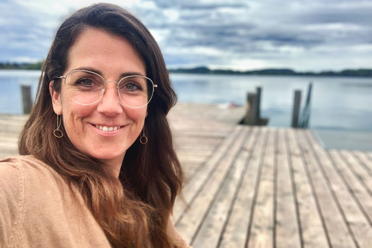 Franziska Schwimmer sitzt auf dem Steg an einem See